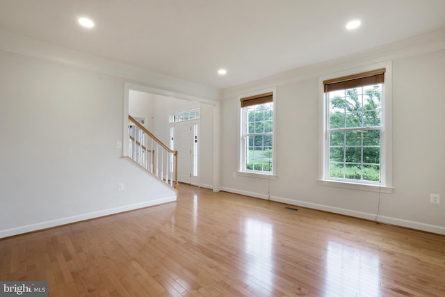 foyer entrance with stairway, baseboards, light wood-style flooring, ornamental molding, and recessed lighting