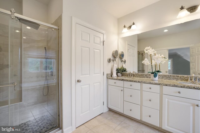 bathroom featuring double vanity, tile patterned floors, and a stall shower