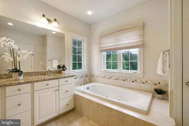 bathroom with a whirlpool tub, vanity, tile patterned floors, and recessed lighting