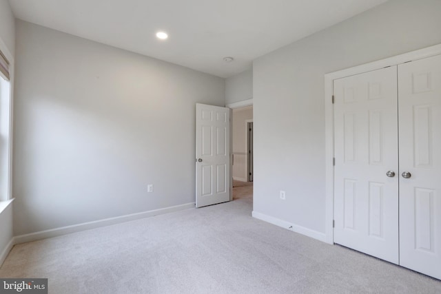 unfurnished bedroom featuring carpet, baseboards, a closet, and recessed lighting