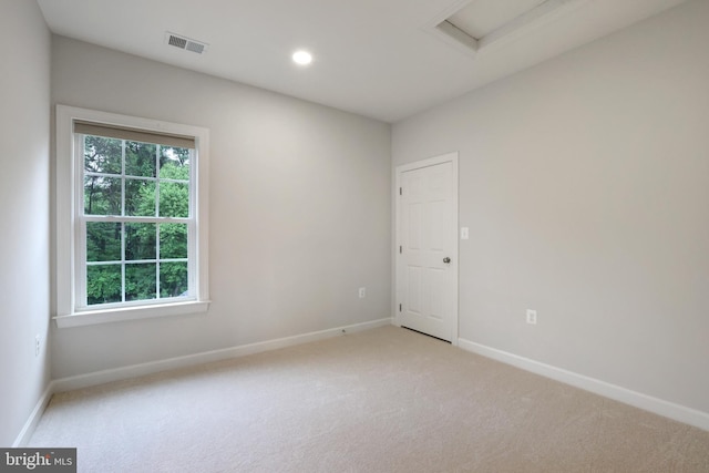 empty room featuring attic access, light carpet, baseboards, and recessed lighting