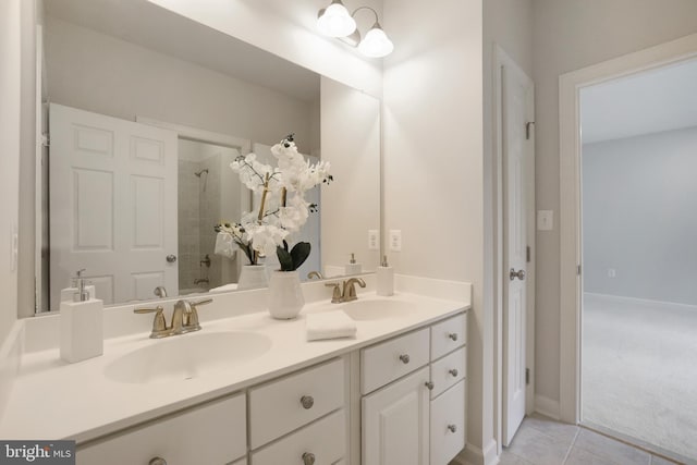 bathroom with double vanity, a tile shower, and tile patterned floors