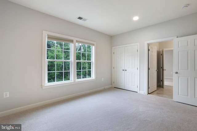 unfurnished bedroom featuring light colored carpet, baseboards, recessed lighting, and a closet