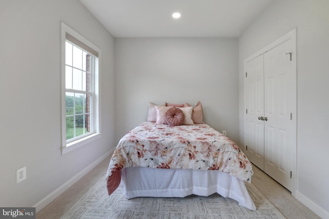 bedroom with baseboards, light carpet, a closet, and recessed lighting