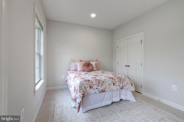 bedroom with light carpet, baseboards, recessed lighting, and a closet