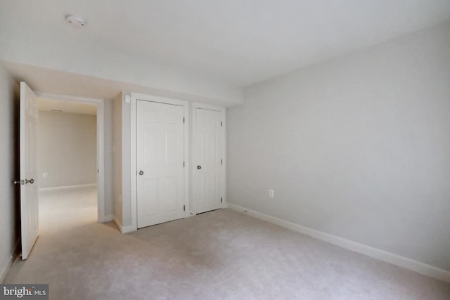 unfurnished bedroom featuring carpet floors and baseboards
