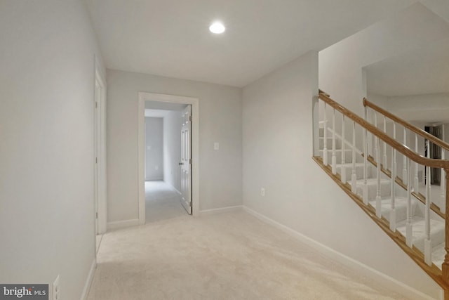 carpeted empty room featuring stairs, baseboards, and recessed lighting