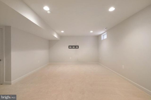 basement featuring recessed lighting, light colored carpet, and baseboards