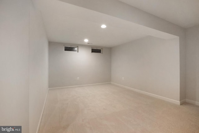 finished basement featuring recessed lighting, light colored carpet, and baseboards