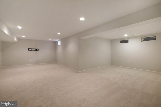 below grade area featuring recessed lighting, light colored carpet, and baseboards