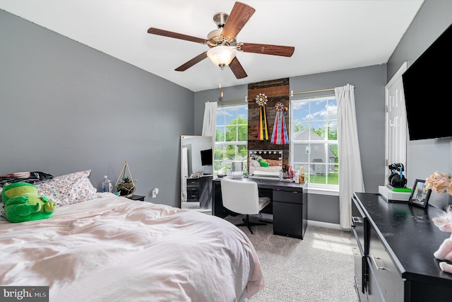 bedroom featuring light carpet, a desk, and ceiling fan