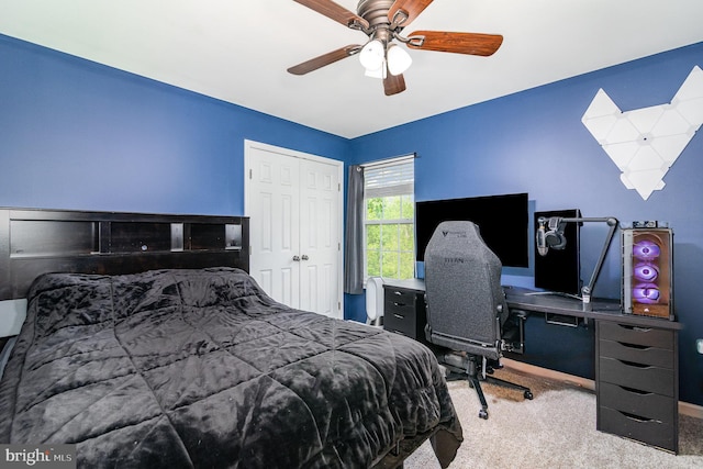 bedroom with carpet flooring, a ceiling fan, a closet, a desk, and baseboards