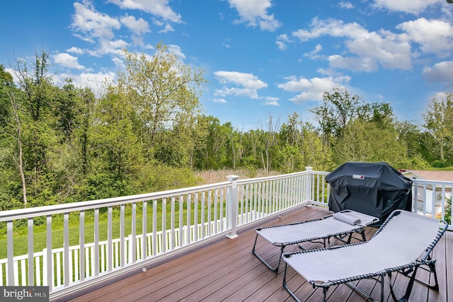 wooden deck featuring grilling area and a forest view