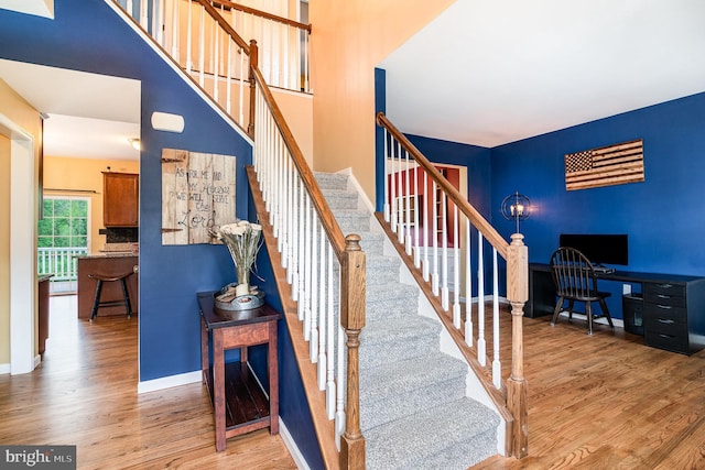 stairs with wood finished floors and baseboards