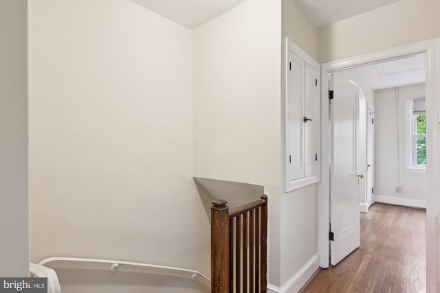 corridor with wood finished floors and baseboards