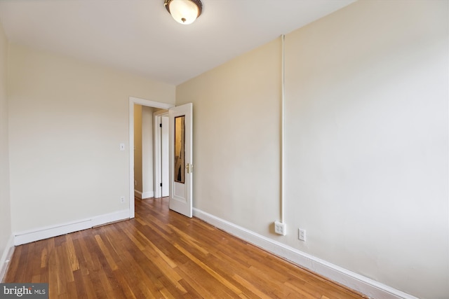 unfurnished room featuring wood finished floors and baseboards