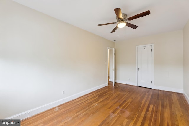 spare room with baseboards, light wood finished floors, and ceiling fan