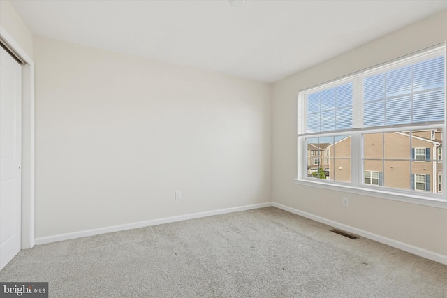unfurnished bedroom featuring carpet floors, baseboards, and a closet