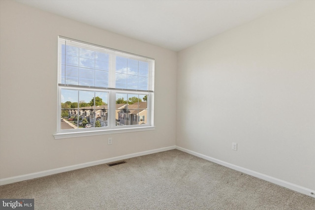 empty room featuring baseboards and carpet flooring