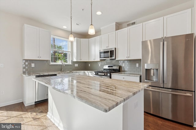 kitchen with stainless steel appliances, a sink, recessed lighting, white cabinetry, and light stone counters