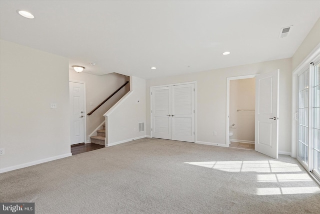 below grade area featuring carpet, stairs, recessed lighting, and baseboards