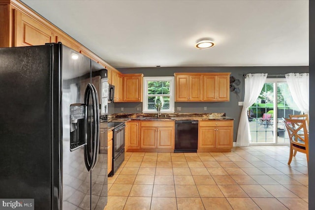3202 Nash Rd, Reading, PA 19608 - kitchen with black appliances, light tile patterned floors, a sink, dark stone counters, and light brown cabinetry