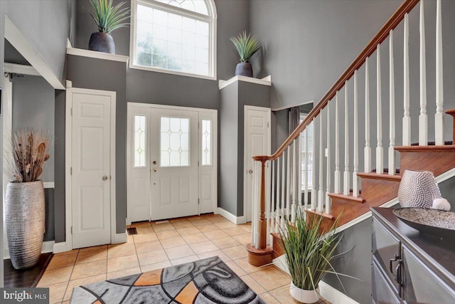 3202 Nash Rd, Reading, PA 19608 - tiled entryway featuring a towering ceiling, stairs, healthy amount of natural light, and baseboards