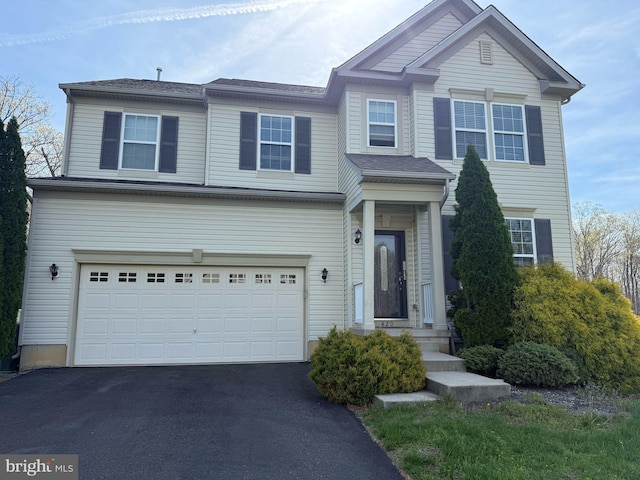 view of front facade featuring a garage and asphalt driveway