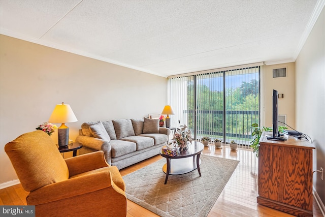 6300 Stevenson Ave Unit 523, Alexandria, VA 22304 - living room featuring crown molding, a textured ceiling, expansive windows, light wood finished floors, and baseboards