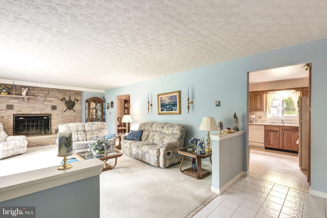 living area featuring light tile patterned flooring, a fireplace, a textured ceiling, and baseboards