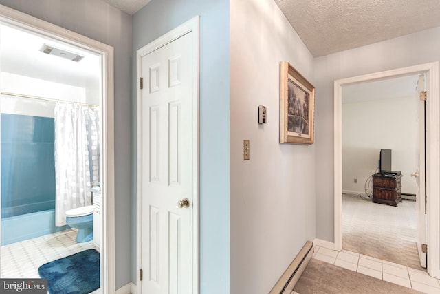hallway with tile patterned floors, a textured ceiling, baseboard heating, carpet flooring, and a baseboard radiator