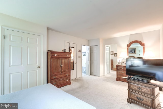 bedroom featuring connected bathroom, baseboards, and light carpet