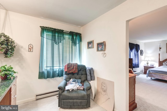 sitting room featuring a baseboard radiator, baseboards, and light wood-style flooring