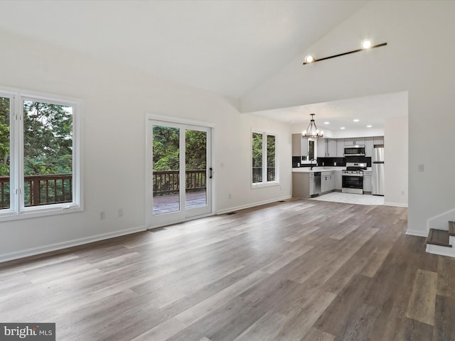 143 Zinn Way, Linden, VA 22642 - unfurnished living room with a chandelier, high vaulted ceiling, wood finished floors, stairway, and recessed lighting