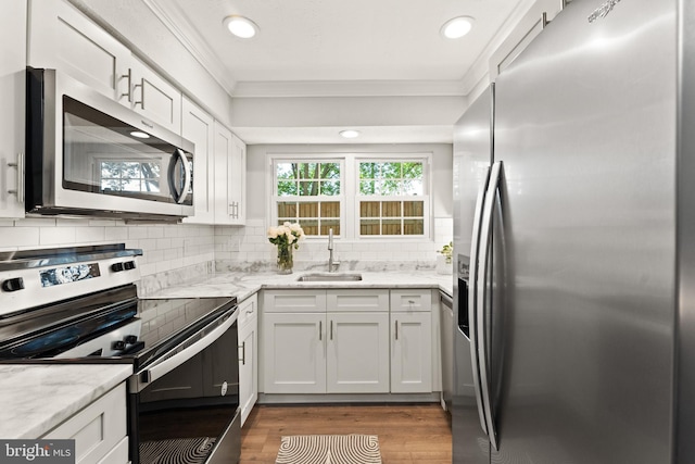 124 Fort Evans Rd SE Unit B, Leesburg, VA 20175 - kitchen featuring appliances with stainless steel finishes, a sink, ornamental molding, white cabinets, and wood finished floors