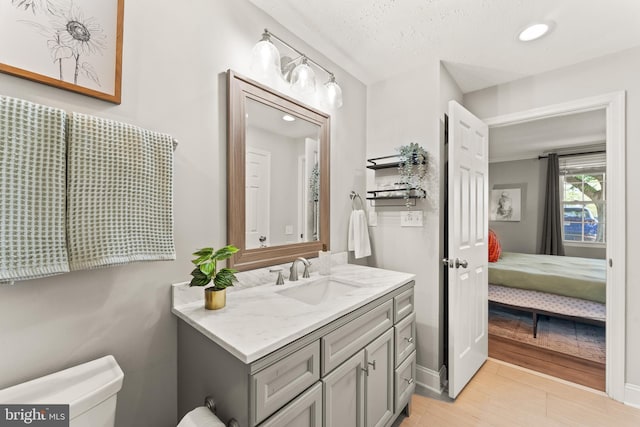 124 Fort Evans Rd SE Unit B, Leesburg, VA 20175 - bathroom with vanity, connected bathroom, toilet, recessed lighting, and wood finished floors