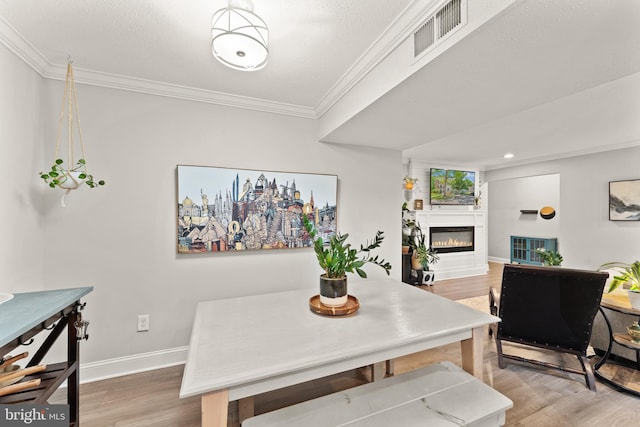 124 Fort Evans Rd SE Unit B, Leesburg, VA 20175 - dining area featuring light wood finished floors, ornamental molding, baseboards, and a glass covered fireplace