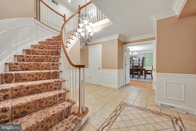 1716 Olmsted Way E, Camp Hill, PA 17011 - stairs featuring a chandelier, tile patterned floors, crown molding, wainscoting, and a decorative wall