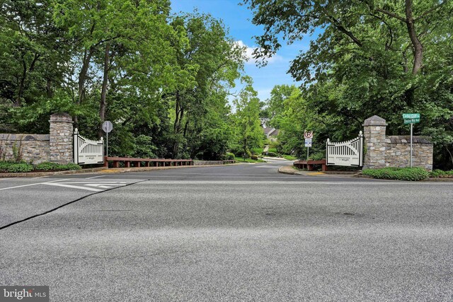 1716 Olmsted Way E, Camp Hill, PA 17011 - view of asphalt road with traffic signs, a gate, and view of scattered trees