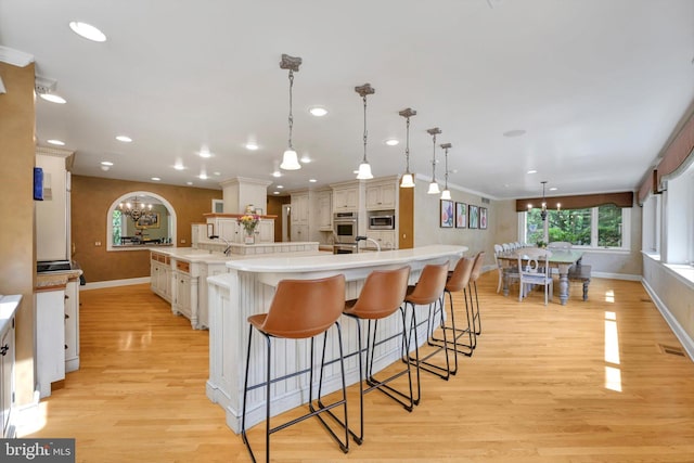 1716 Olmsted Way E, Camp Hill, PA 17011 - kitchen featuring a chandelier, baseboards, light wood-style flooring, a spacious island, and a breakfast bar