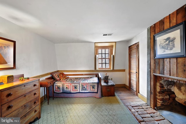 bedroom with wooden walls, a closet, and baseboards