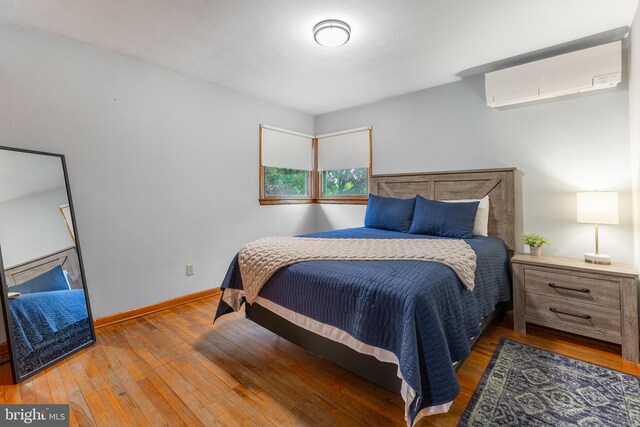 1051 Taylor St, State College, PA 16803 - bedroom with a wall unit AC, wood finished floors, and baseboards