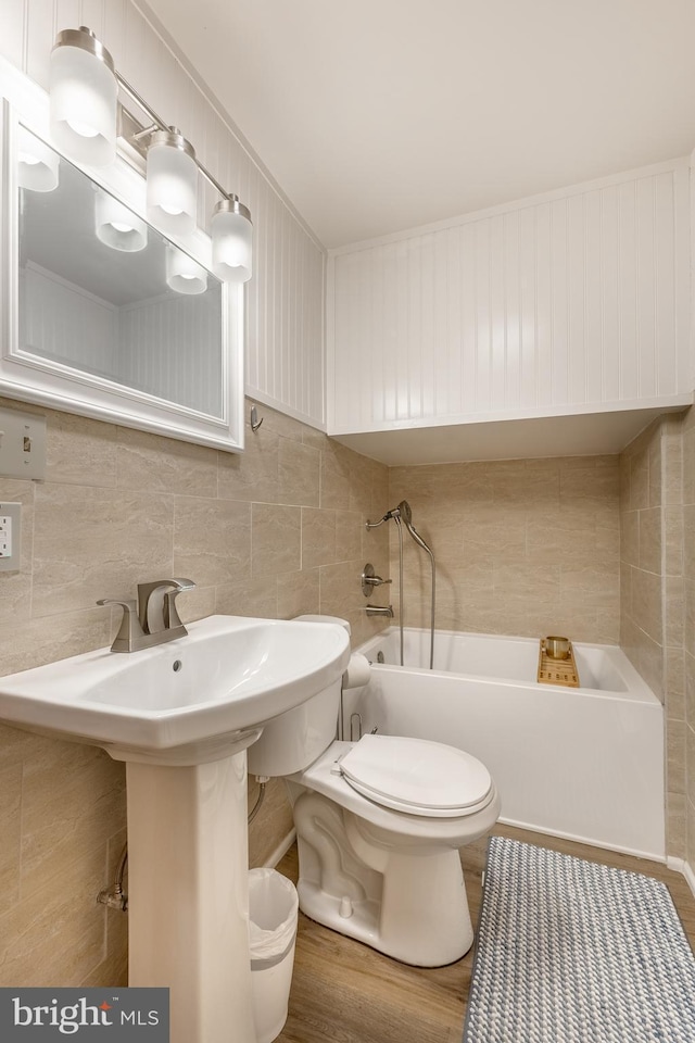 1051 Taylor St, State College, PA 16803 - bathroom with a bathtub, toilet, tile walls, and tasteful backsplash