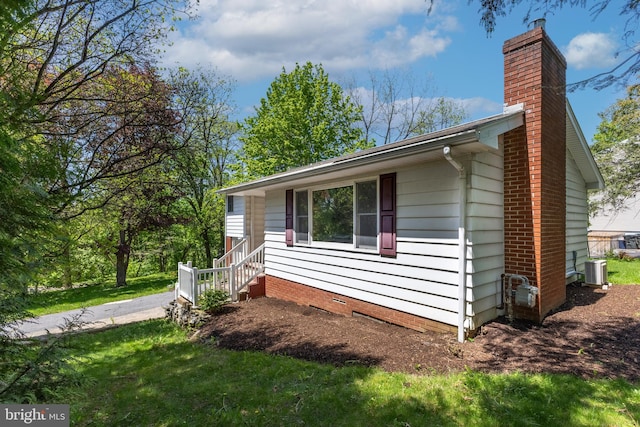 1051 Taylor St, State College, PA 16803 - view of home's exterior with a chimney, cooling unit, and a yard