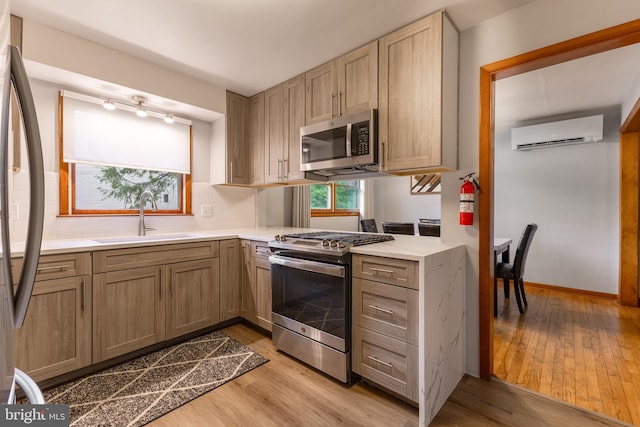1051 Taylor St, State College, PA 16803 - kitchen with stainless steel appliances, a sink, a wall mounted AC, light wood-type flooring, and backsplash
