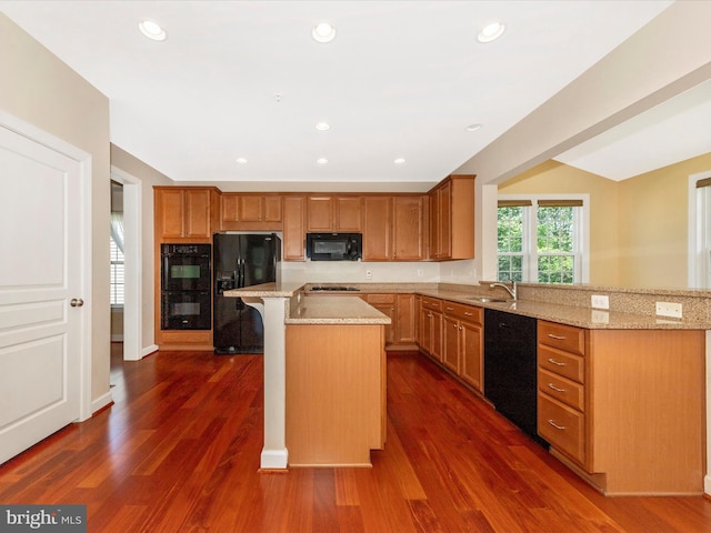 15 Wagon Shed Ln, Middletown, MD 21769 - kitchen with black appliances, a sink, a peninsula, a kitchen bar, and dark wood finished floors