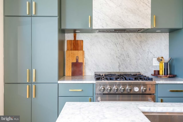 kitchen featuring high end stainless steel range oven, decorative backsplash, built in refrigerator, and light countertops