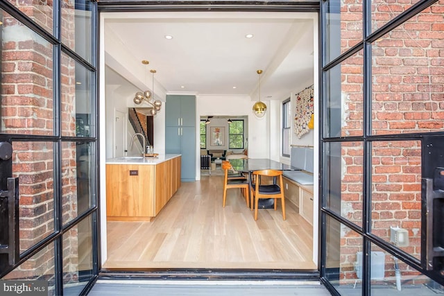 interior space featuring light wood-style floors, a sink, and pendant lighting