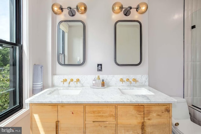 full bathroom with double vanity and toilet
