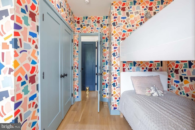 bedroom with light wood-type flooring and wallpapered walls
